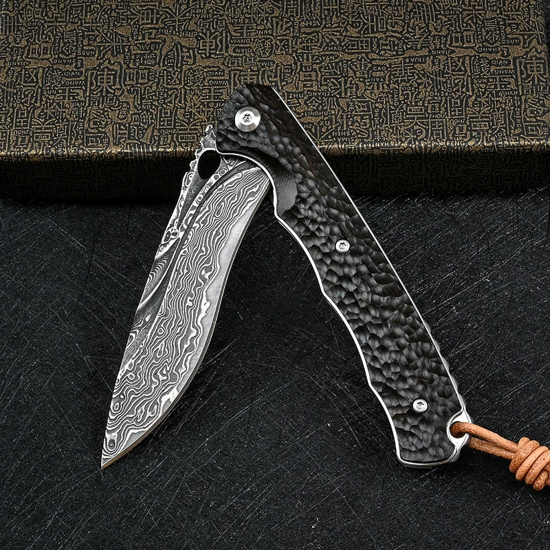 Damascus steel folding knife with textured black handle shown open