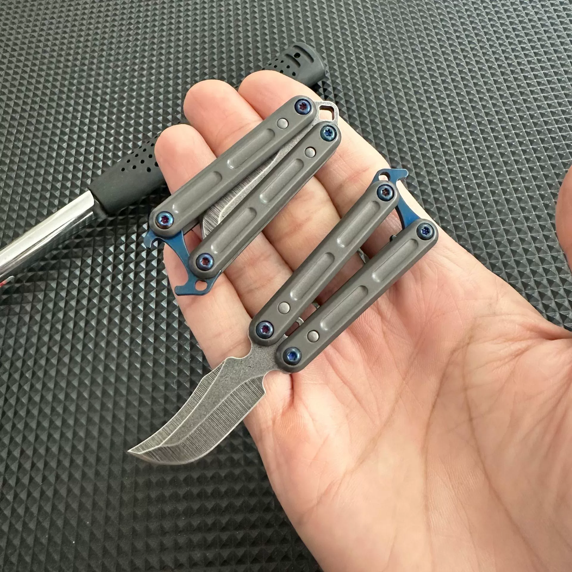Mini stainless steel butterfly knife shown in hand